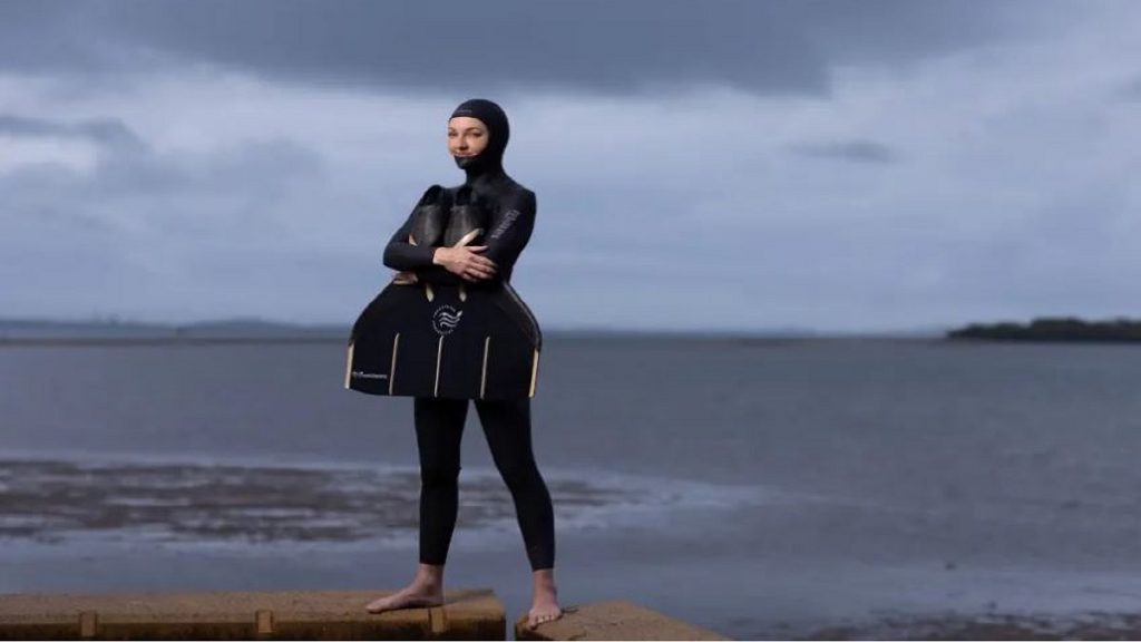 La mujer que puede descender al fondo del mar con un solo respiro de pie junto a la playa.